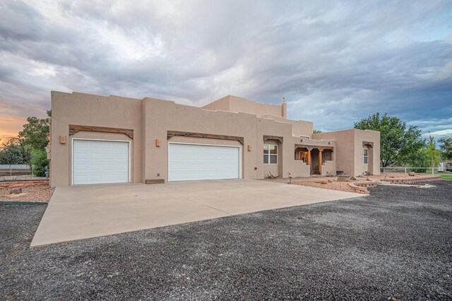 pueblo-style home with a garage