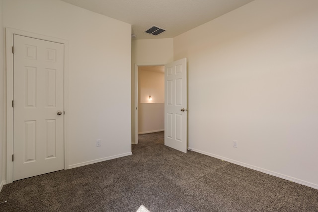 unfurnished bedroom with dark carpet