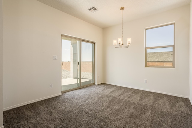 carpeted spare room featuring a notable chandelier