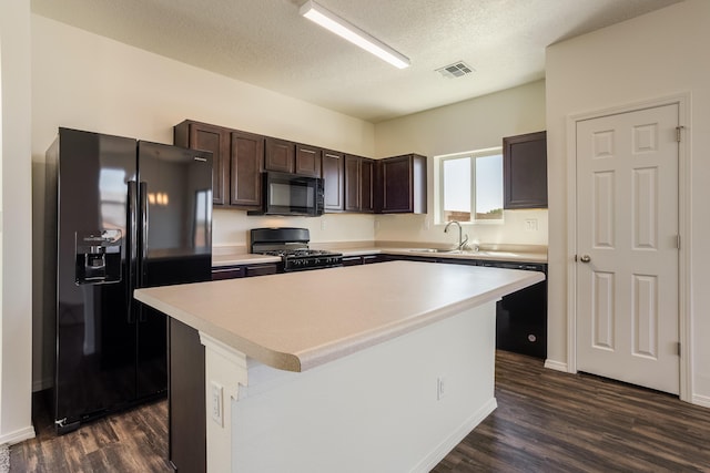 kitchen with a center island, sink, a textured ceiling, dark brown cabinets, and black appliances