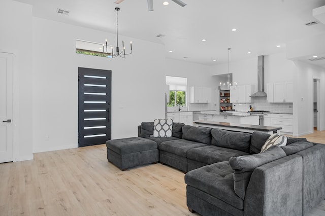 living area featuring an inviting chandelier, visible vents, light wood finished floors, and recessed lighting