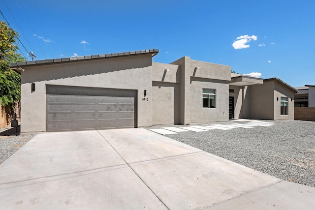 view of front of house featuring an attached garage, driveway, and stucco siding