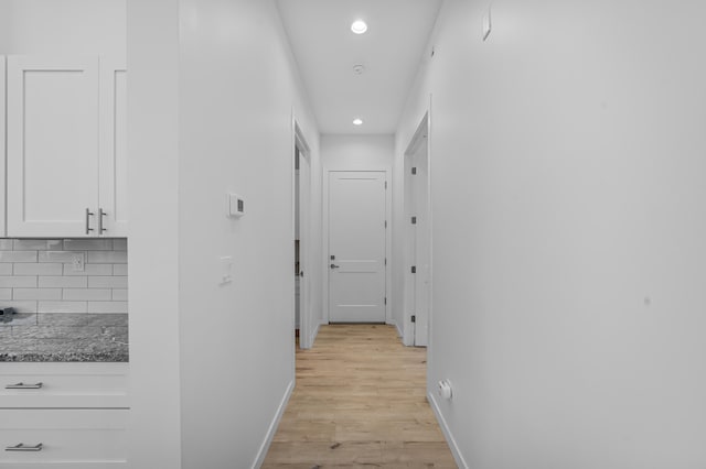 hallway with light wood-style flooring, baseboards, and recessed lighting