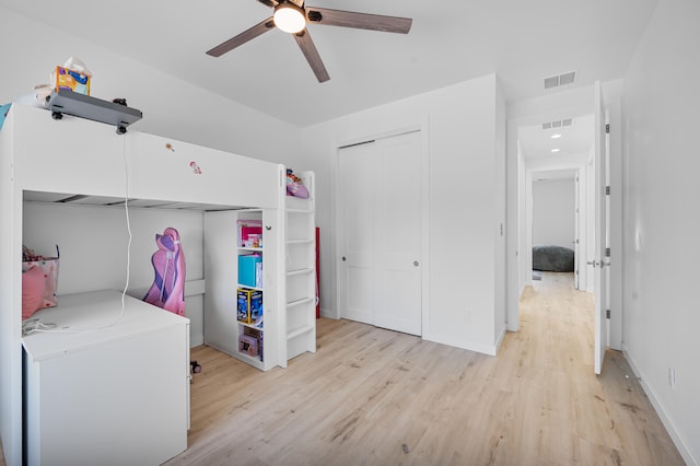 bedroom featuring refrigerator, a closet, visible vents, and light wood-style flooring