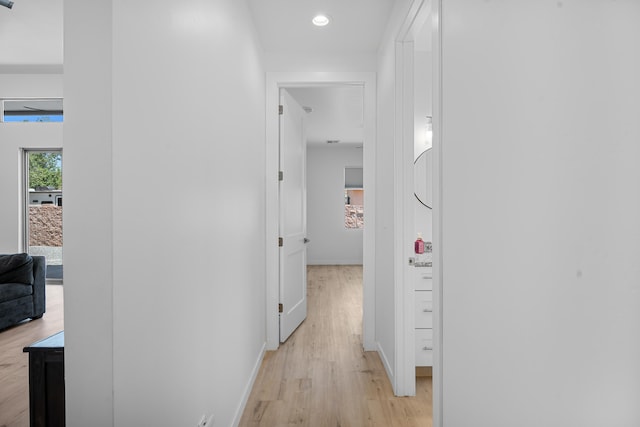 hallway with light wood-style floors, recessed lighting, and baseboards