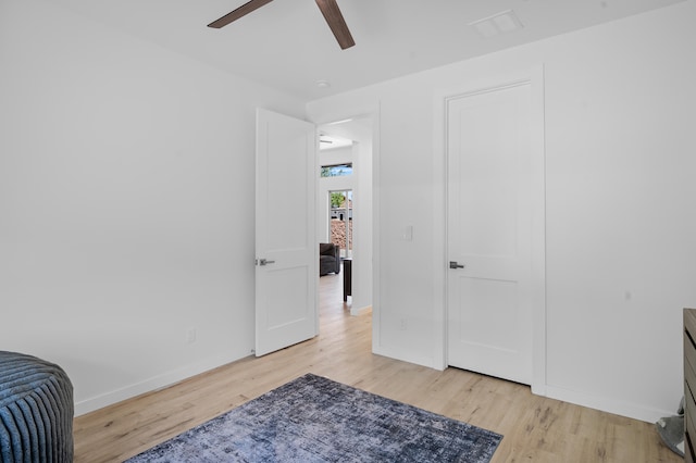 bedroom featuring light wood-style floors, baseboards, and a ceiling fan