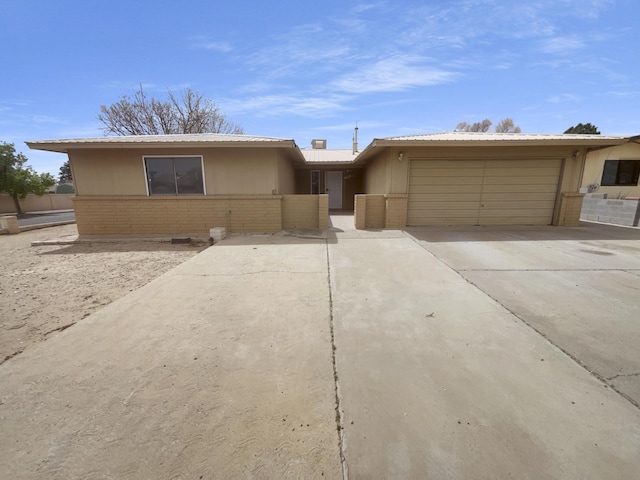 ranch-style home featuring driveway, an attached garage, and brick siding
