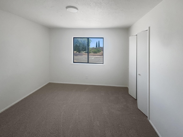 unfurnished bedroom with dark carpet