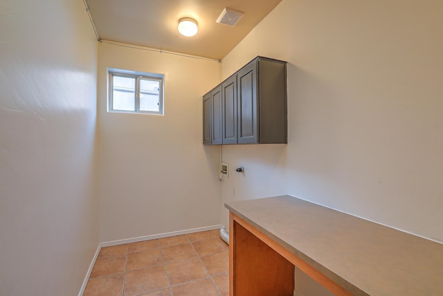 washroom featuring visible vents, baseboards, washer hookup, light tile patterned floors, and cabinet space