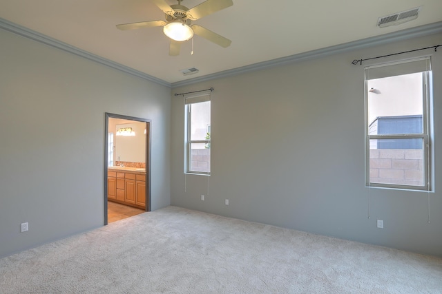 spare room featuring light carpet, visible vents, crown molding, and a ceiling fan