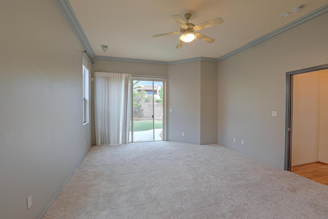 empty room with light carpet, visible vents, crown molding, and ceiling fan