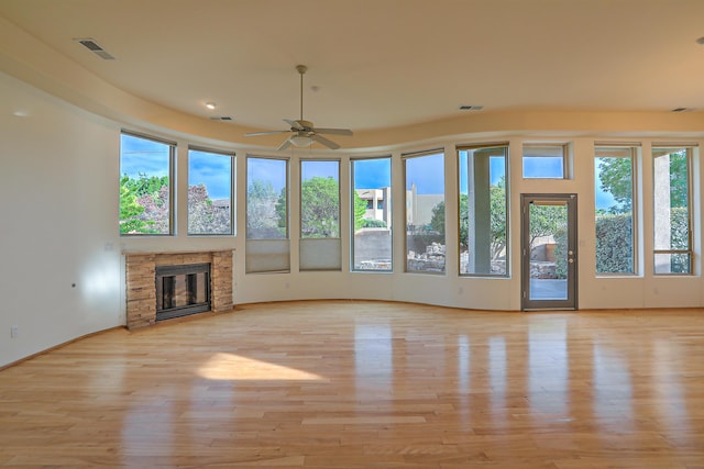 unfurnished living room with light wood-type flooring, visible vents, and a fireplace