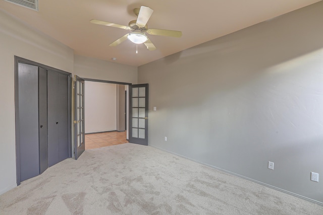 unfurnished bedroom featuring visible vents, a closet, carpet floors, french doors, and ceiling fan