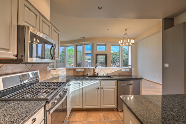 kitchen featuring sink, hanging light fixtures, light tile patterned flooring, stainless steel appliances, and a chandelier