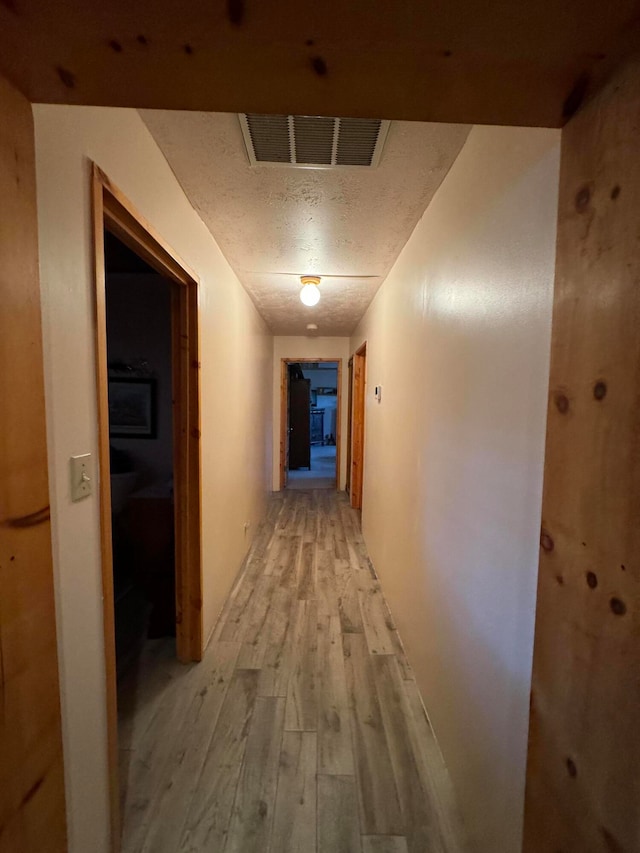 57 Edmundo Rd, Belen, NM 87002 - hallway with a textured ceiling and light hardwood / wood-style flooring