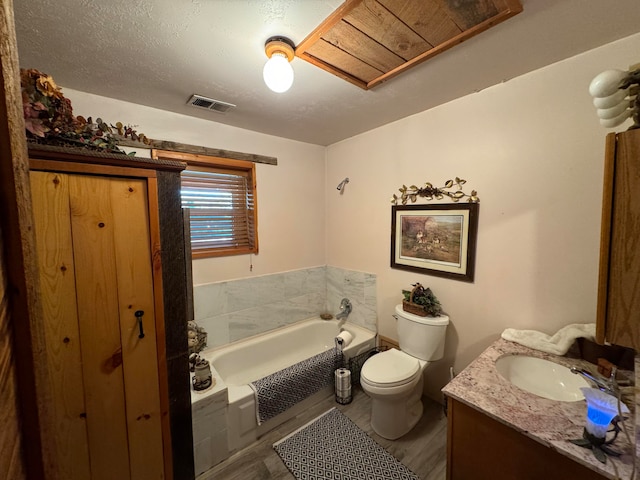 57 Edmundo Rd, Belen, NM 87002 - bathroom featuring hardwood / wood-style flooring, toilet, a tub, vanity, and a textured ceiling