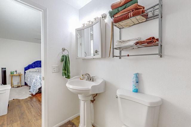 bathroom with toilet and hardwood / wood-style floors