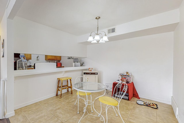 tiled dining room featuring a chandelier