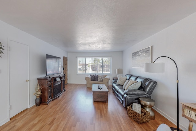 living room with a textured ceiling and light hardwood / wood-style floors