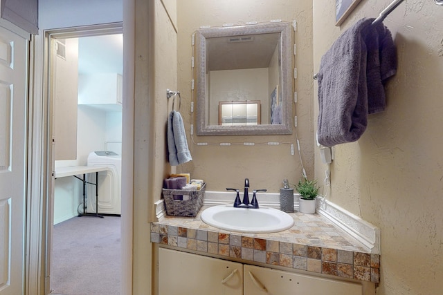 bathroom featuring washer / dryer and vanity