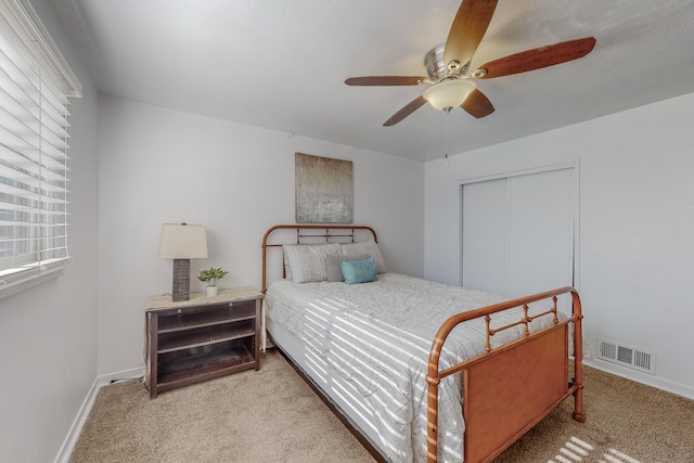 bedroom featuring a closet, ceiling fan, and light carpet