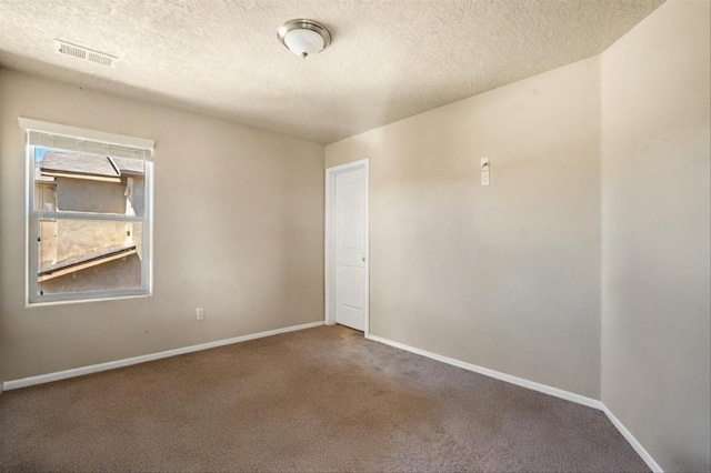 unfurnished room with carpet flooring and a textured ceiling