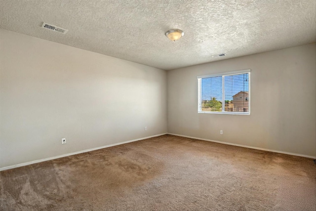 carpeted spare room with a textured ceiling