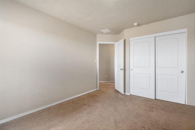 unfurnished bedroom featuring carpet flooring, a closet, and a textured ceiling