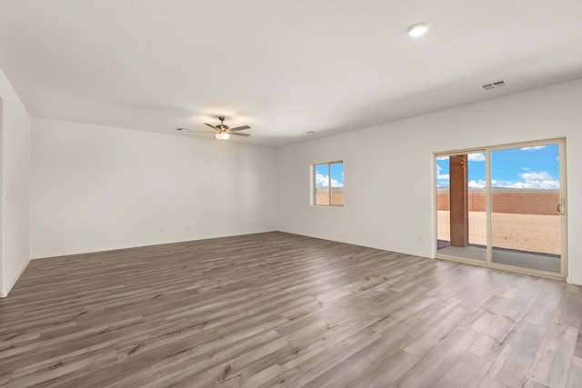 spare room featuring baseboards, ceiling fan, visible vents, and wood finished floors