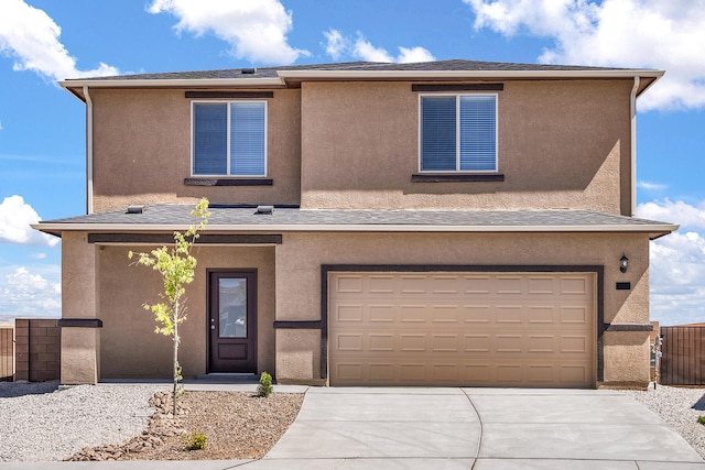 view of front of house featuring an attached garage, fence, concrete driveway, and stucco siding