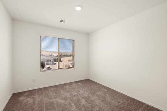 unfurnished room with carpet floors, baseboards, and visible vents