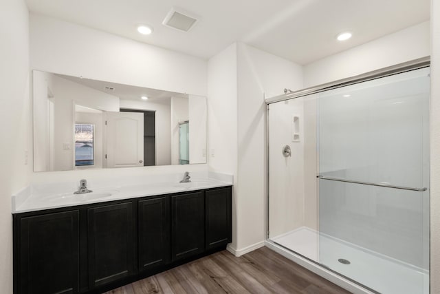 bathroom with a shower stall, visible vents, and a sink