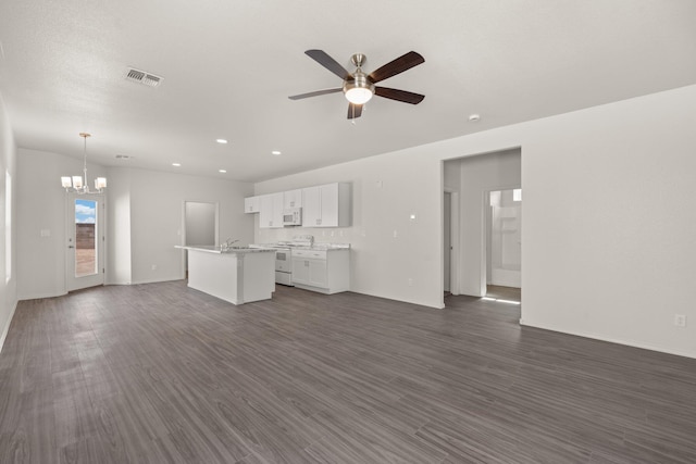 unfurnished living room with recessed lighting, visible vents, dark wood finished floors, and ceiling fan with notable chandelier