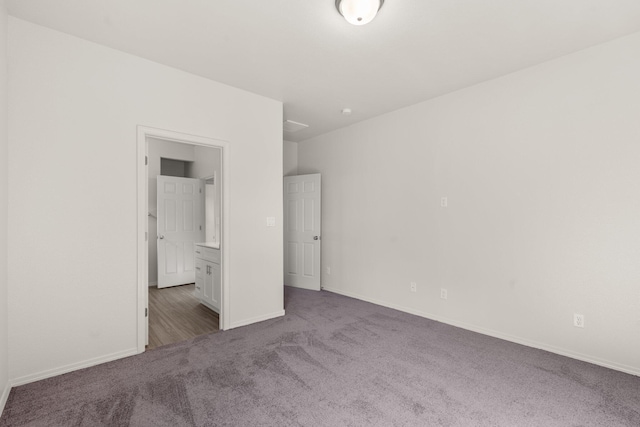 unfurnished bedroom with carpet, ensuite bath, and baseboards