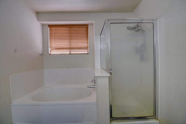 bathroom featuring a textured ceiling and plus walk in shower