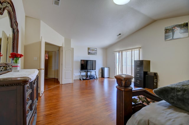 bedroom with lofted ceiling and hardwood / wood-style floors