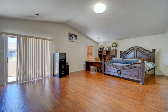 bedroom with wood-type flooring, access to exterior, and vaulted ceiling