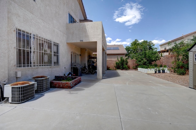 view of patio / terrace featuring a storage shed and central air condition unit