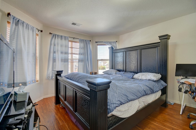 bedroom featuring a textured ceiling and dark hardwood / wood-style floors