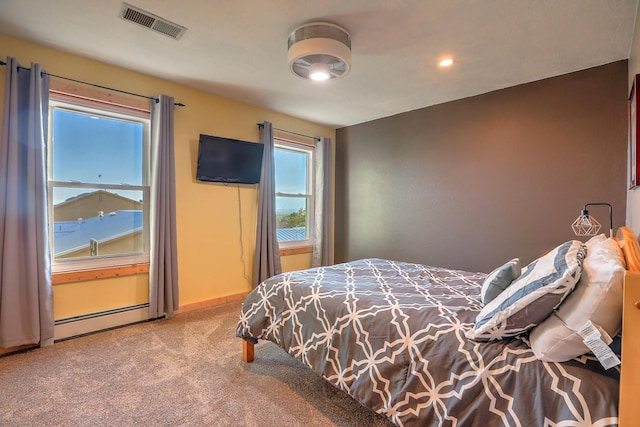 carpeted bedroom with baseboard heating, visible vents, and baseboards