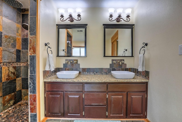 bathroom featuring double vanity, a sink, and a walk in shower