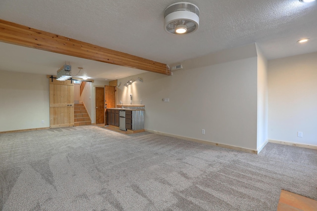 unfurnished living room with light colored carpet, beamed ceiling, baseboards, and stairs