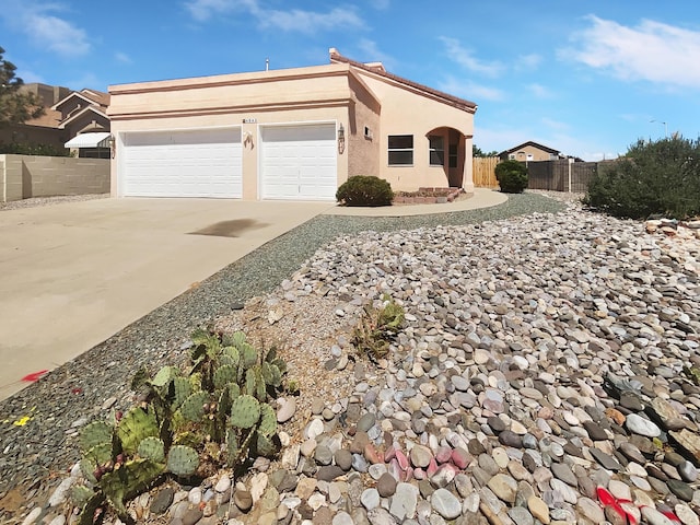 view of front of home featuring a garage, fence, concrete driveway, a tiled roof, and stucco siding