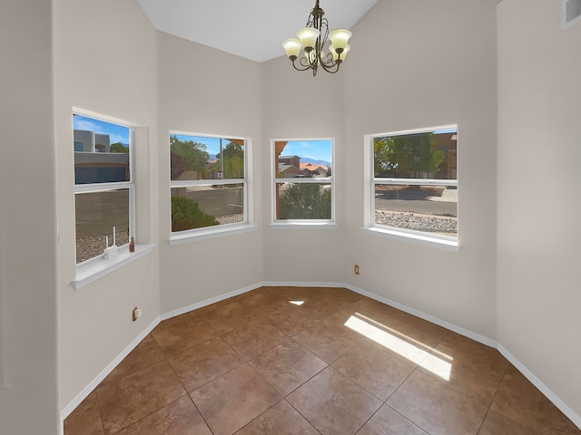 interior space with tile patterned flooring, plenty of natural light, high vaulted ceiling, and a chandelier