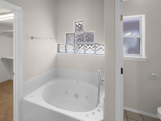 full bathroom with tile patterned flooring, baseboards, and a tub with jets