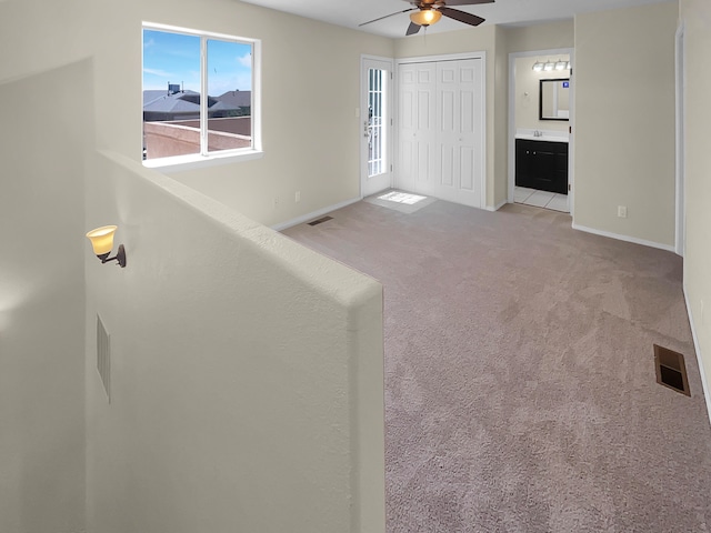 interior space featuring ceiling fan and light carpet