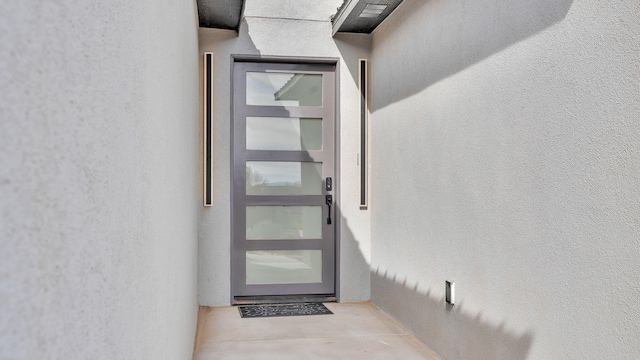 view of exterior entry featuring stucco siding