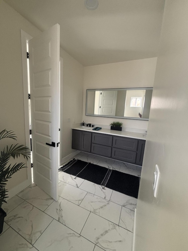 bathroom with baseboards, marble finish floor, and vanity