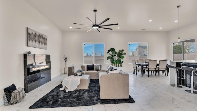 living room featuring a fireplace, marble finish floor, baseboards, ceiling fan, and recessed lighting