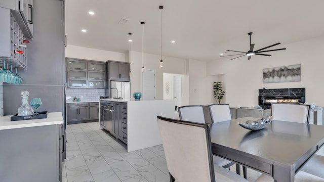 dining room featuring a ceiling fan, marble finish floor, a premium fireplace, and recessed lighting